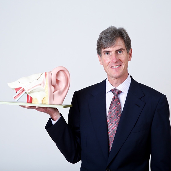 Dr. H. holding a plastic ear model