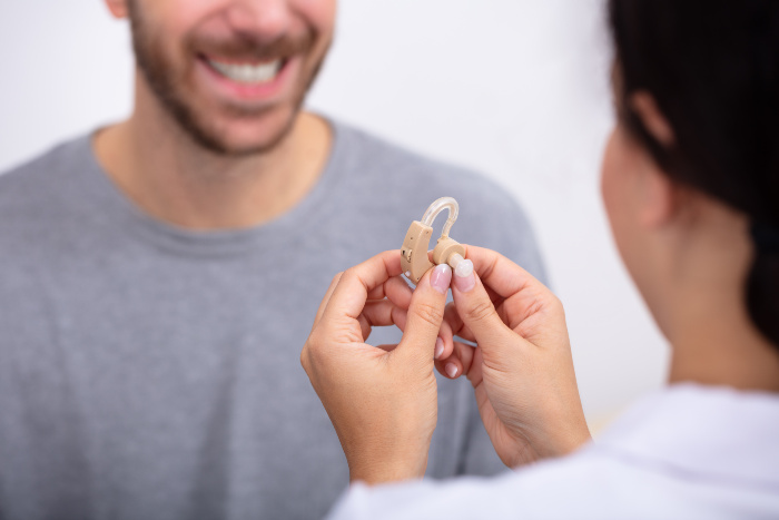 Audiologist helping a patient with their first hearing aid in Colorado Springs