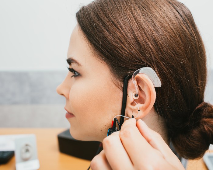 Audiologist adjusting behind-the-ear hearing aid for patient in Colorado Springs, CO